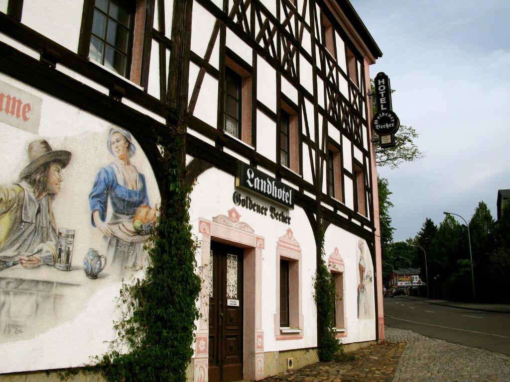 ein Gebäude mit Gemälden auf der Seite in der Unterkunft Landhotel Goldener Becher in Limbach - Oberfrohna