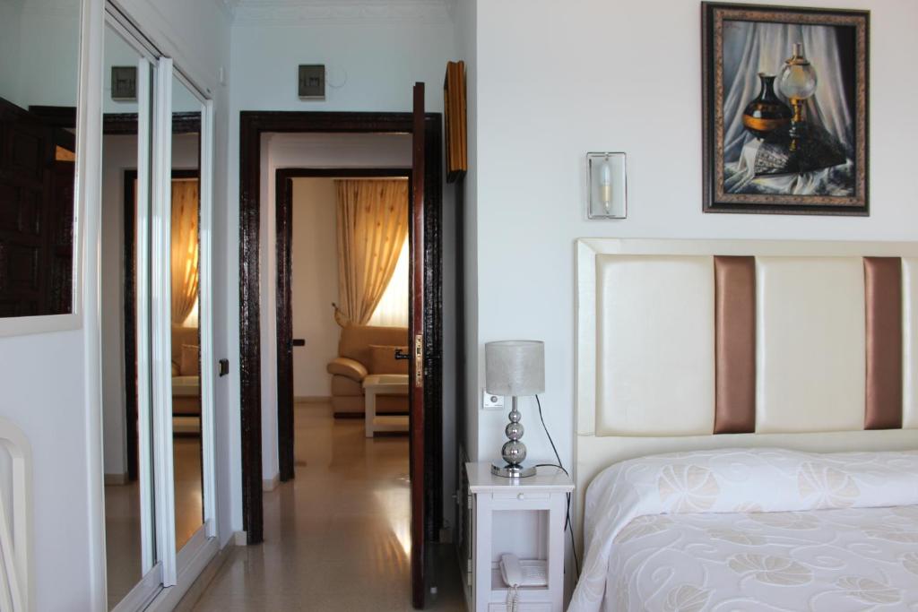 a bedroom with a bed and a room with a chair at Hotel Paraíso Del Mar in Nerja