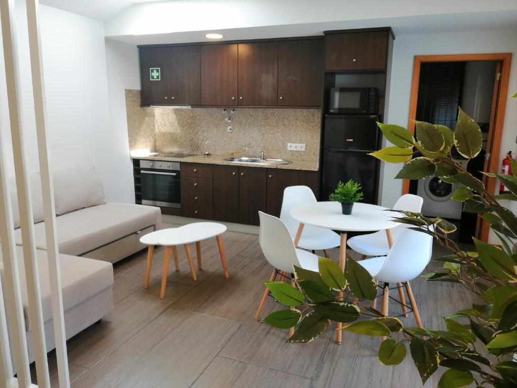 een keuken en een woonkamer met een tafel en stoelen bij The Blue Angel in Viana do Castelo