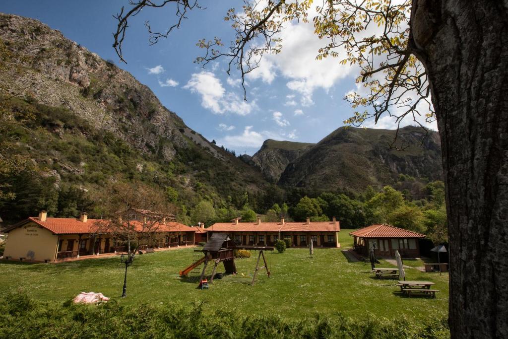 Apartamentos Camin De Pelayo في Las Rozas: حديقة فيها ملعب امام جبل