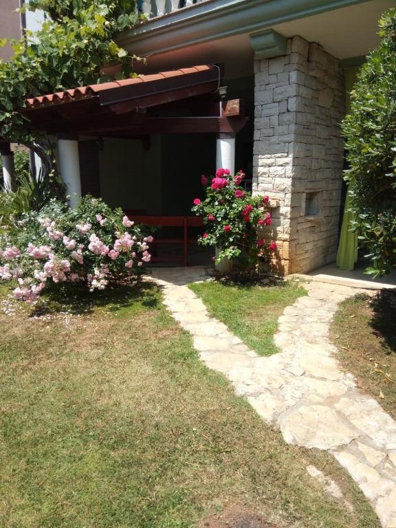 a house with flowers on the side of it at Villa Verde Apartments and Rooms in Premantura