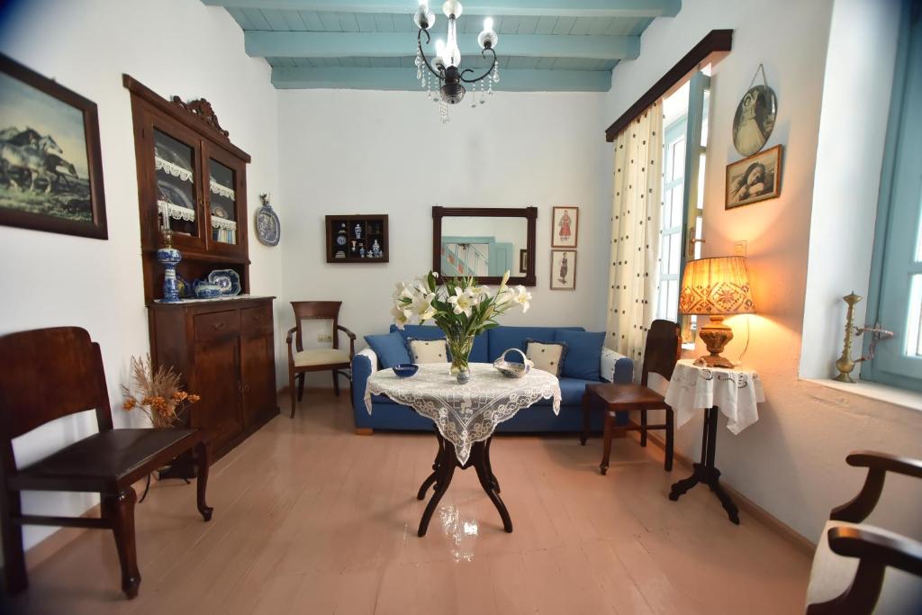 salon ze stołem i niebieską kanapą w obiekcie Traditional house by the sea w mieście Mandrákion
