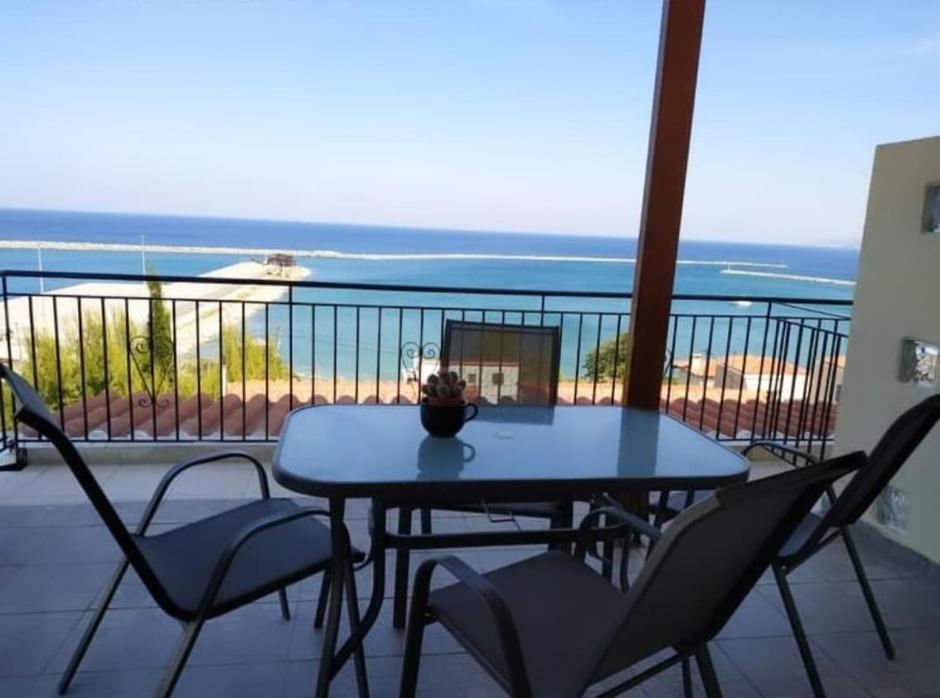 a table and chairs on a balcony with a view of the ocean at Avra Studios in Kymi