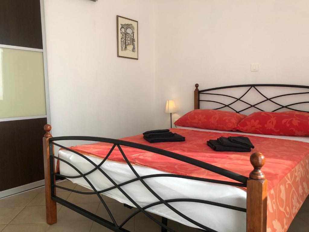 a bedroom with a bed with a red comforter at Dalmatia Apartments in Podstrana