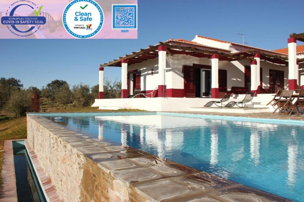 a villa with a swimming pool and a house at Monte Da Coelha AL in Redondo