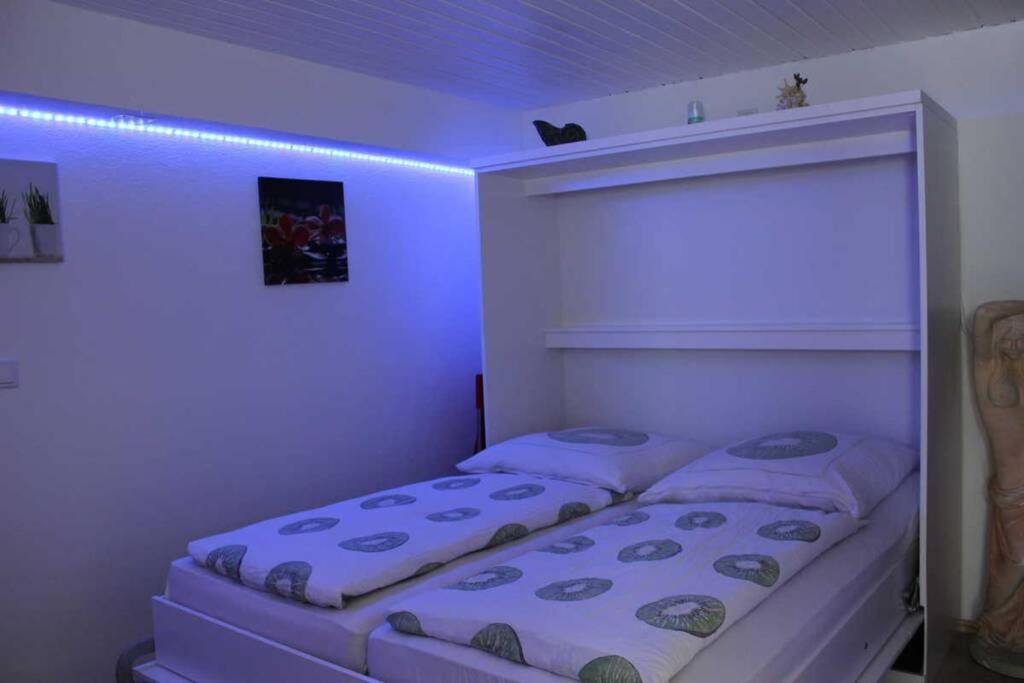 a bed in a room with a purple light at Apartment in grüner Umgebung-EG in Allensbach