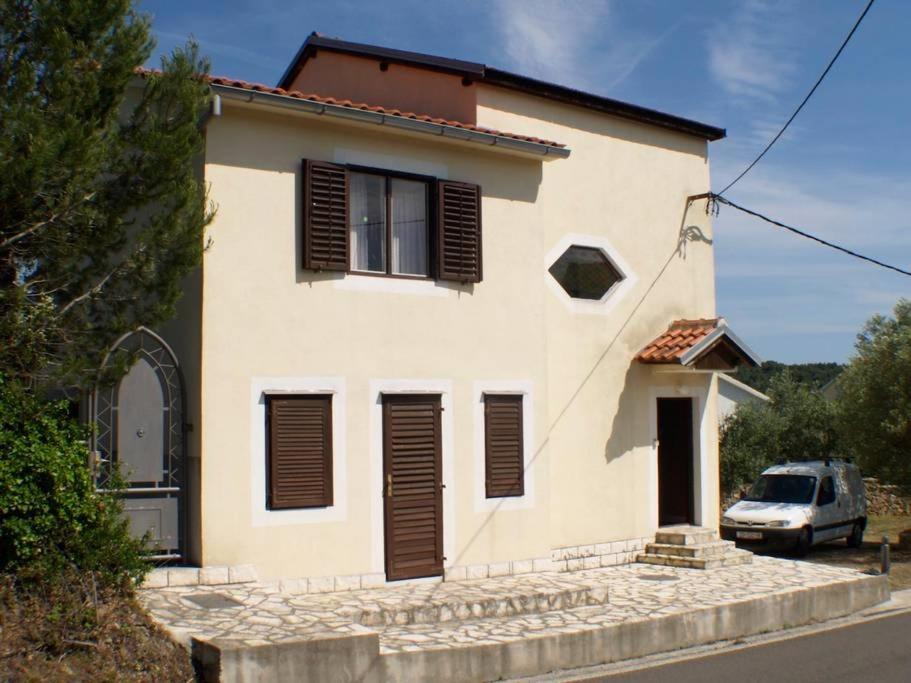 dom z samochodem zaparkowanym przed nim w obiekcie Holiday house in Kukljica with sea view, terrace, air conditioning, Wi-Fi (4572-1) w mieście Kukljica