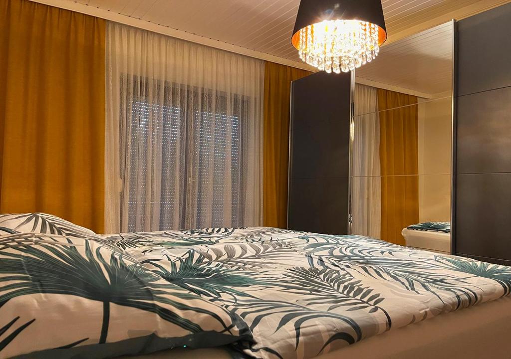 sypialnia z łóżkiem i żyrandolem w obiekcie Apartments Fiore am Naturschwimmbad! w mieście Puch