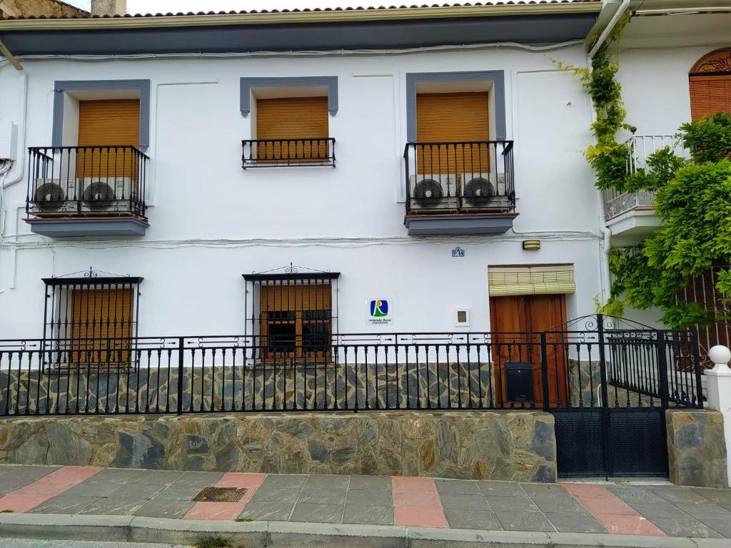 a white building with windows and balconies at Casa Montilla in Granada