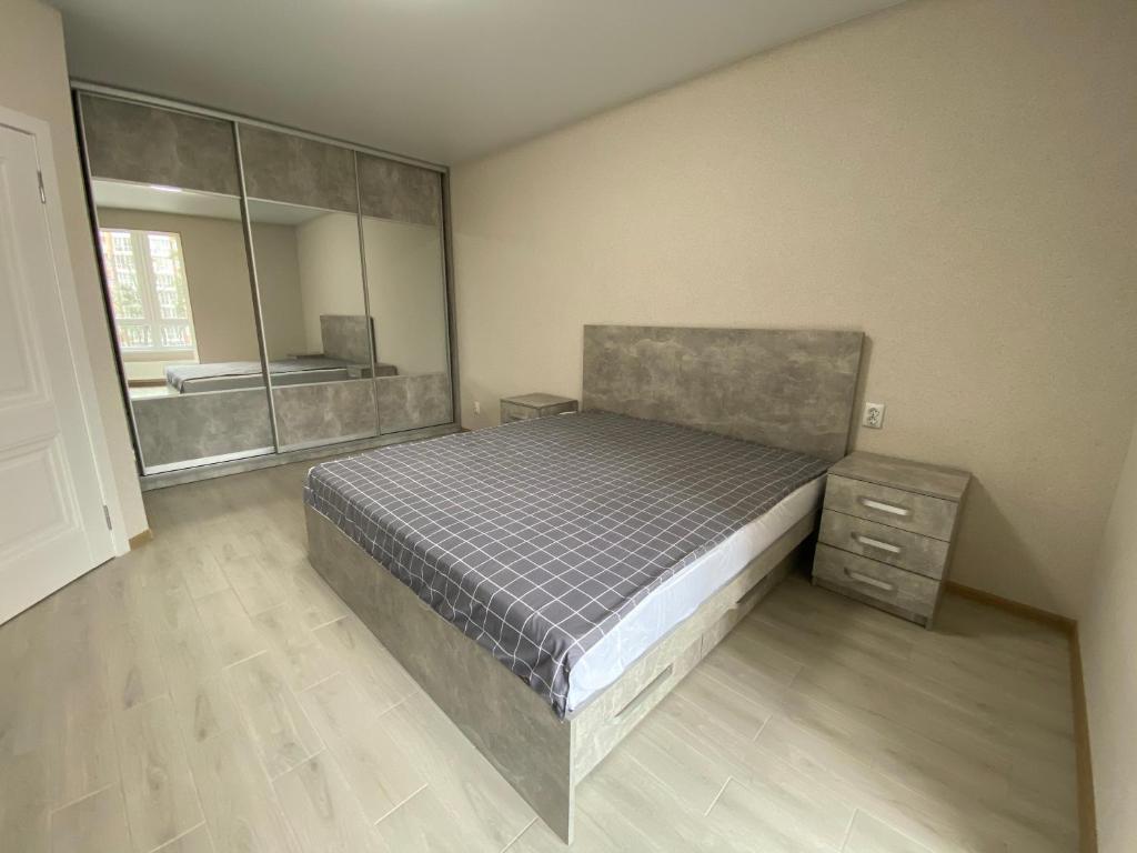 een slaapkamer met een bed en een grote spiegel bij Fresh Residence apartment (ЖК Резиденція) in Vinnytsya