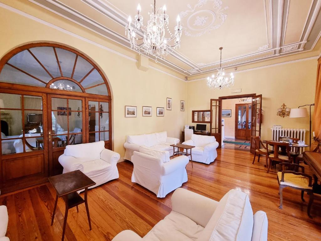 a living room with white furniture and a chandelier at Hotel Canali - Le Cinque Terre in Rapallo