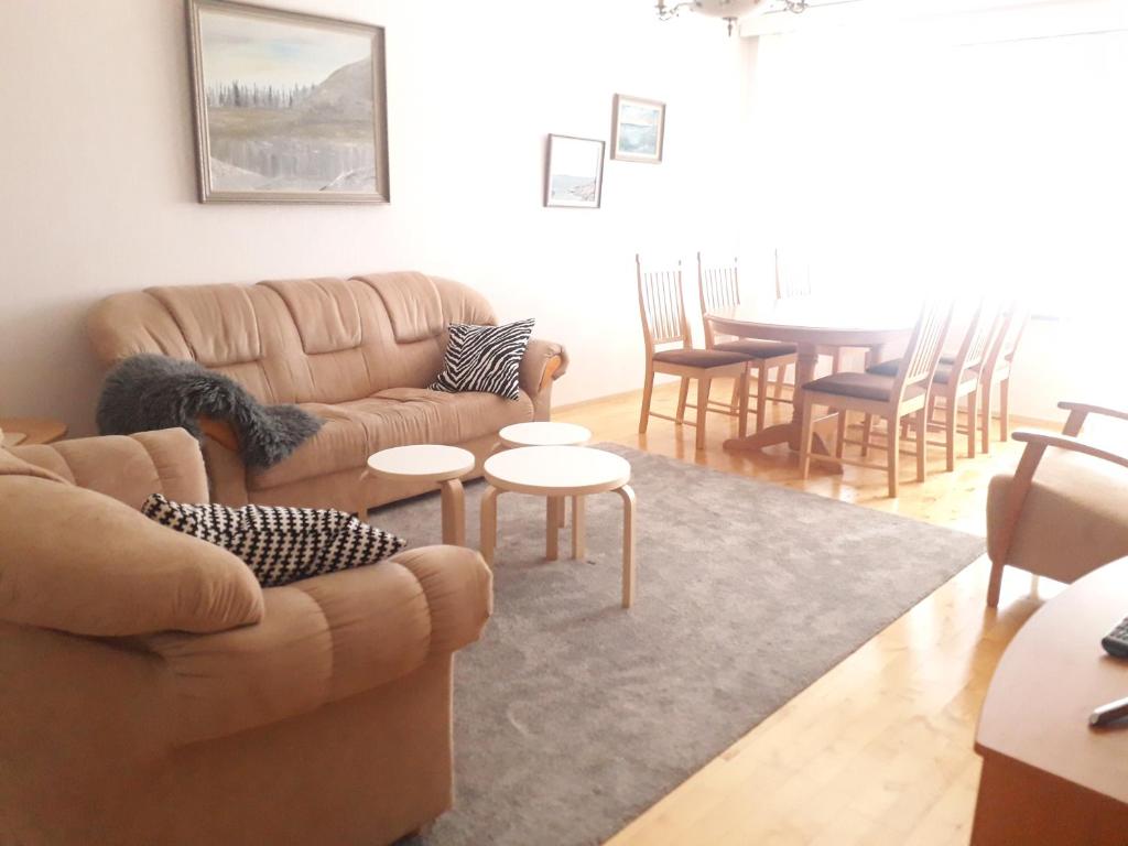 a living room with couches and a table and chairs at Puutarhakatu 1 bdr 62m2 in Turku