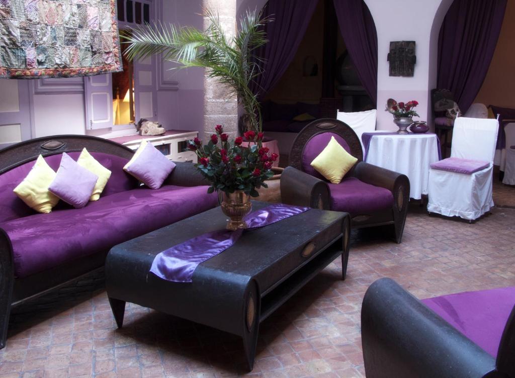 a living room with purple couches and a table at Casa Lila & Spa in Essaouira