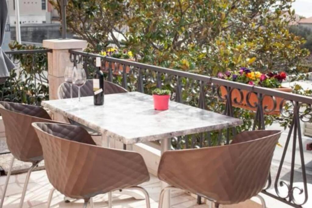 una mesa con una botella de vino y sillas en el balcón en Apartman Monaco, en Makarska