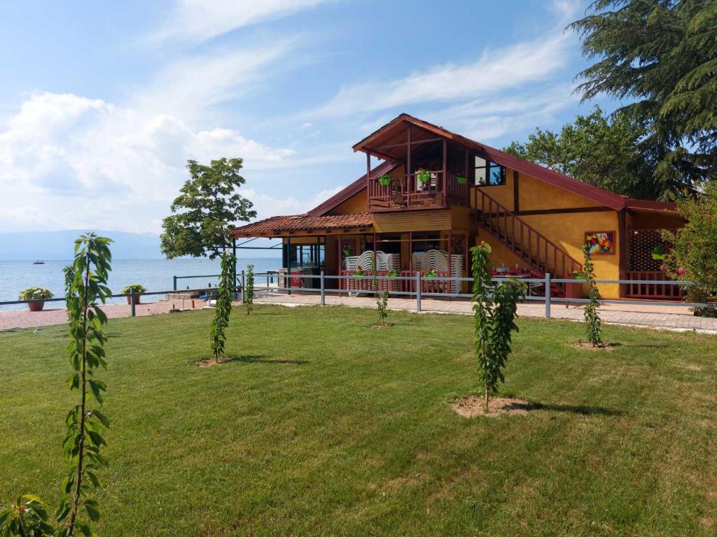 een huis op het strand met bomen in de tuin bij Villa art colony in Ohrid