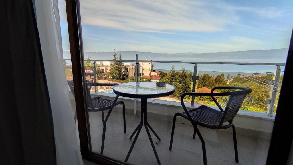 a table and chairs on a balcony with a view at Villa Sv. Stefan in Ohrid