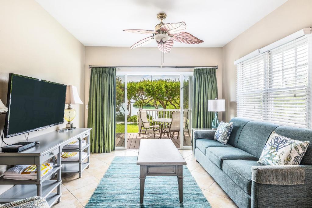 a living room with a blue couch and a tv at Duck Key Retreat Villa #5105 in Duck Key