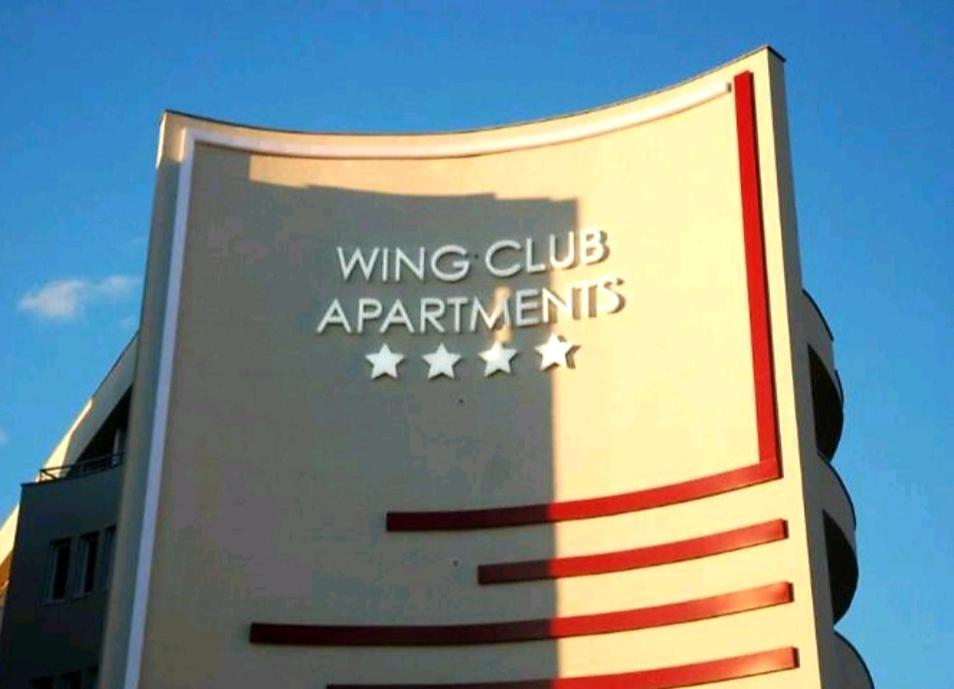 een bord voor vleugelclubs appartementen aan de zijkant van een gebouw bij RoyalWings apartman Jagodina in Jagodina