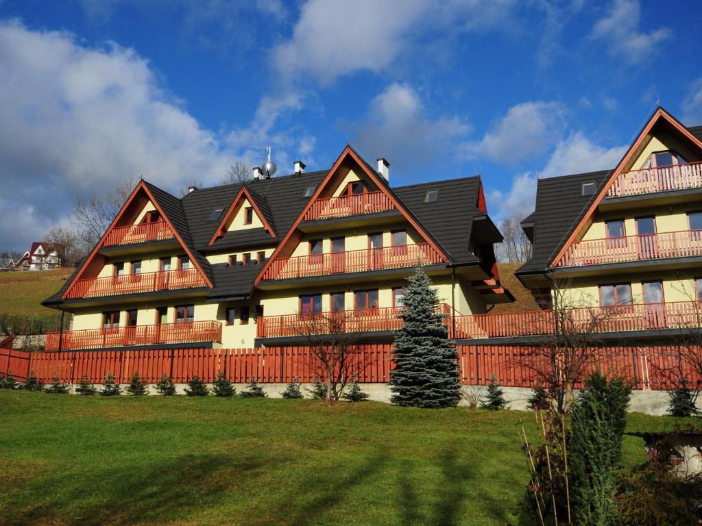 ein großes Haus mit schwarzem Dach in der Unterkunft Apartamenty Domino - Zakopane in Zakopane