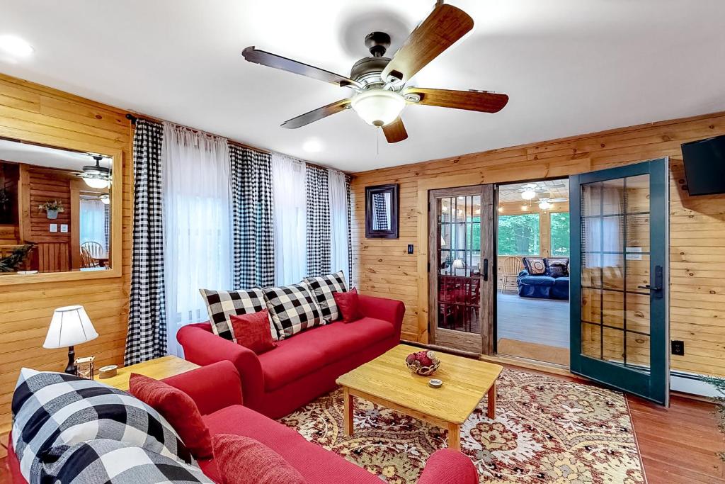 a living room with a red couch and a ceiling fan at The Mitchell House in North Woodstock