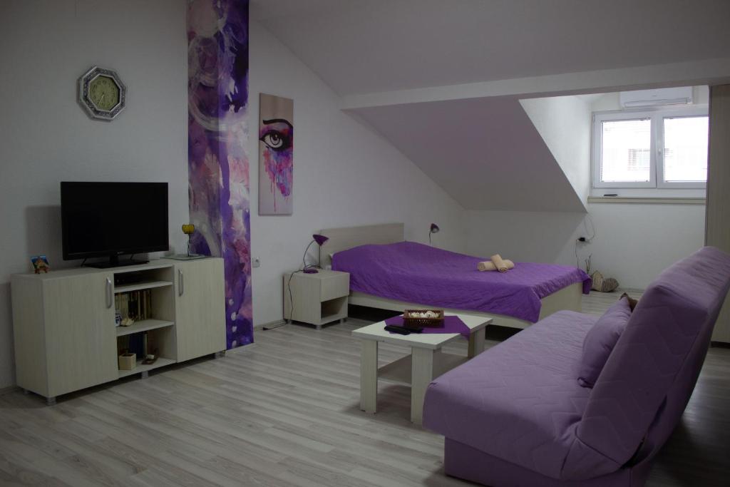 - un salon doté d'un mobilier violet et d'un canapé violet dans l'établissement Markulev Apartment, à Ohrid