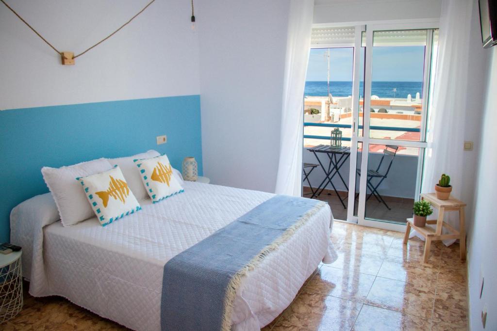 H El Palmeral Playa في موجاكار: غرفة نوم مع سرير وإطلالة على المحيط