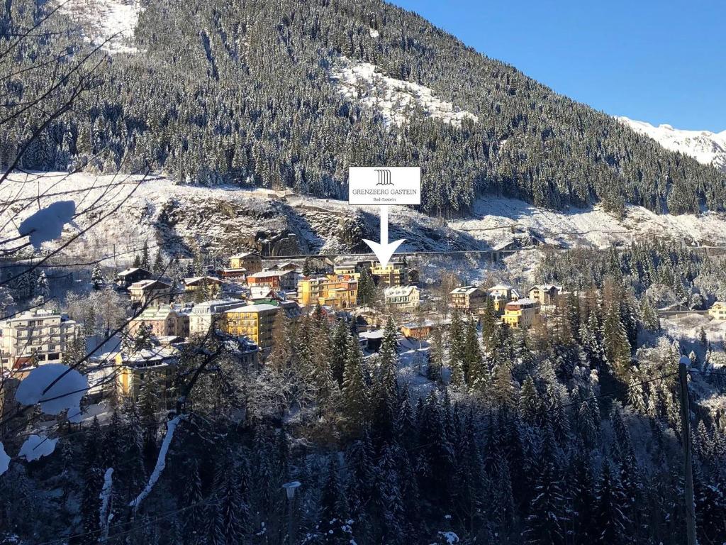 um sinal no topo de uma montanha com uma cidade em Grenzberg - Bad Gastein em Bad Gastein