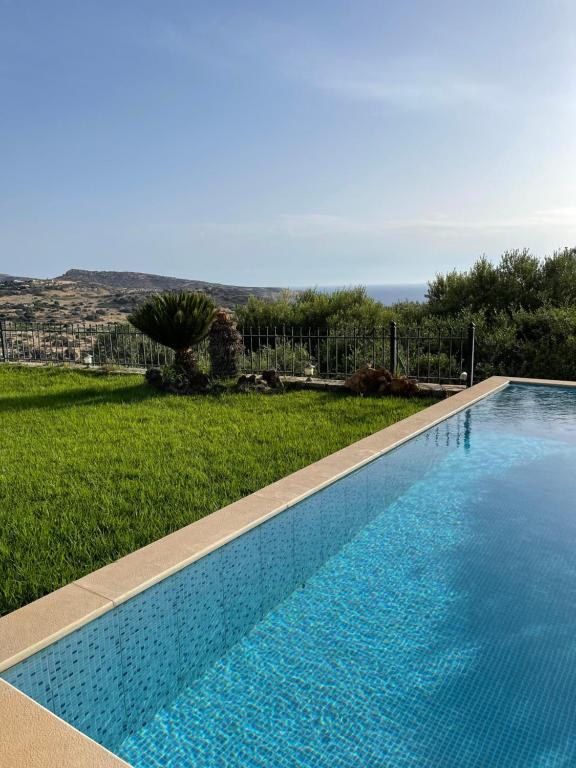 a swimming pool with a view of a yard at Villa Georgia in Pitsidia