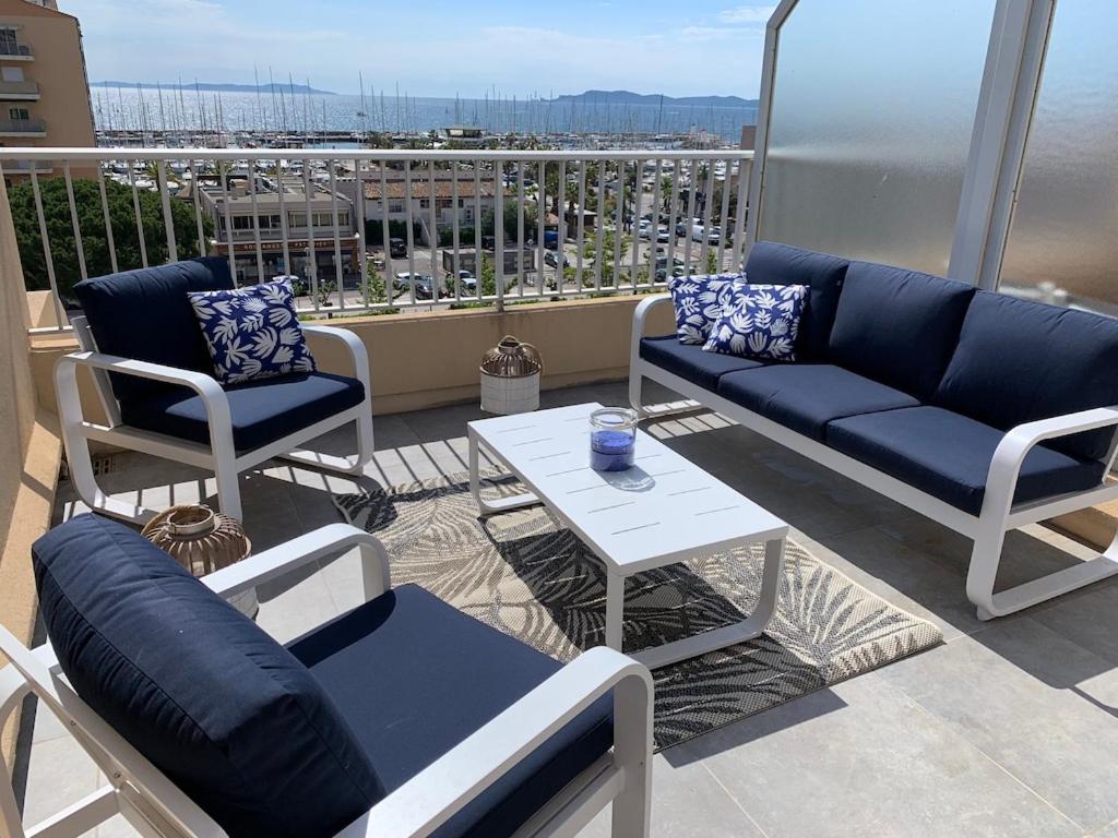 a balcony with a couch and chairs and a table at L'EFFET MER, DUPLEX SUR LE PORT AVEC SES 2 TERRASSES VUE MER in Hyères