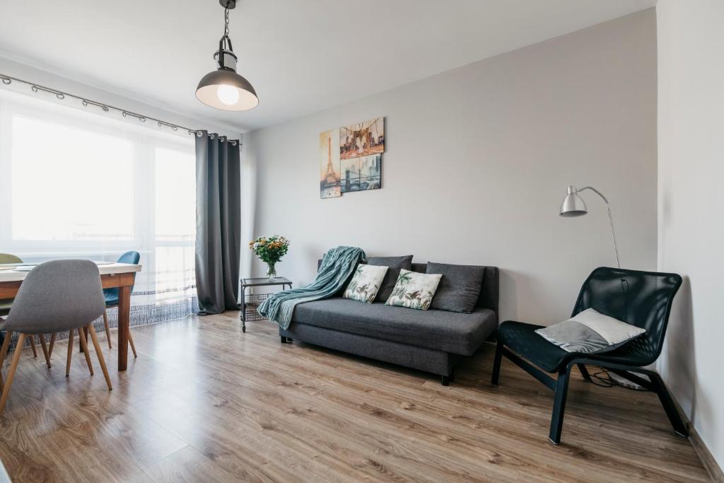uma sala de estar com um sofá e uma mesa em Nocosfera Apartament Serbinów em Kalisz