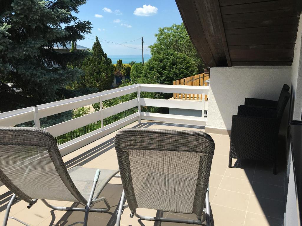 d'un balcon avec des chaises et une clôture blanche. dans l'établissement Nefelejcs Apartman, à Balatonvilágos