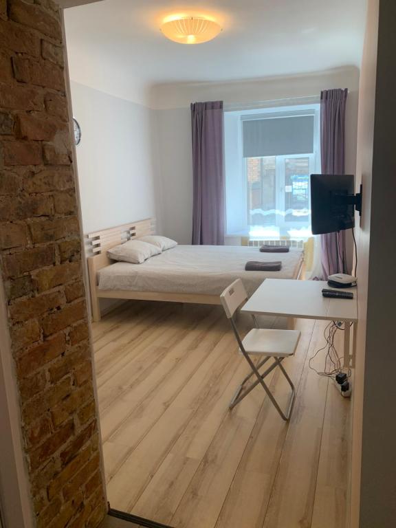 a bedroom with a bed and a desk and a table at Riverside Promenade apartment S in Rīga