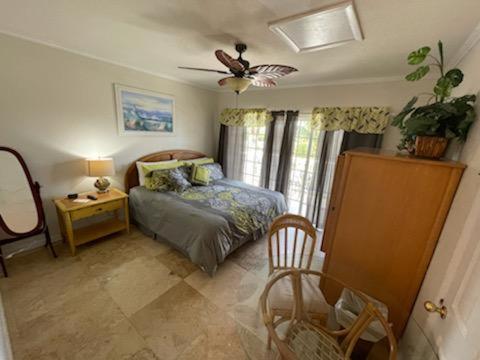 1 dormitorio con cama, mesa y ventilador en Coconut Cove Resort & Marina, en Islamorada