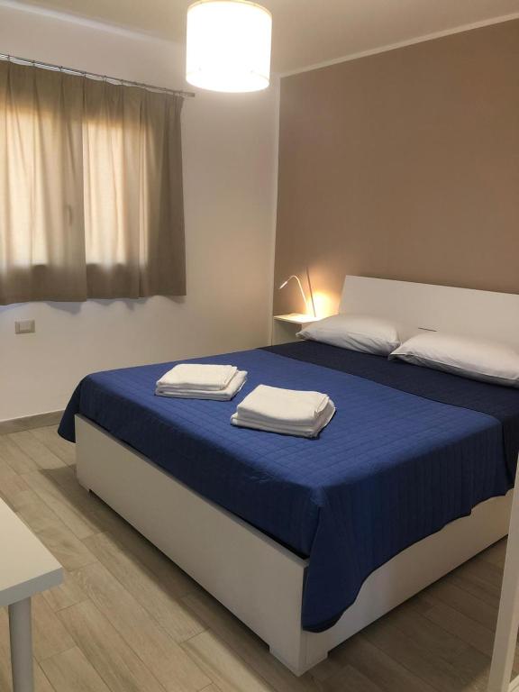 a bedroom with a bed with two towels on it at Casa Giulia in Niscemi