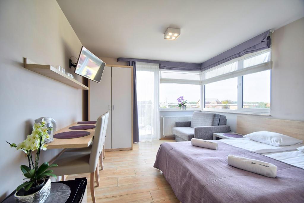 ウストロニエ・モルスキエにあるVilla Martikaのベッドルーム1室(ベッド1台、テーブル、ソファ付)