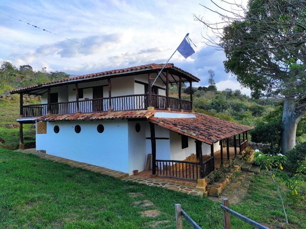 una casa con balcón y una bandera. en Casa Ceiba de Mirabel-Barichara en Barichara