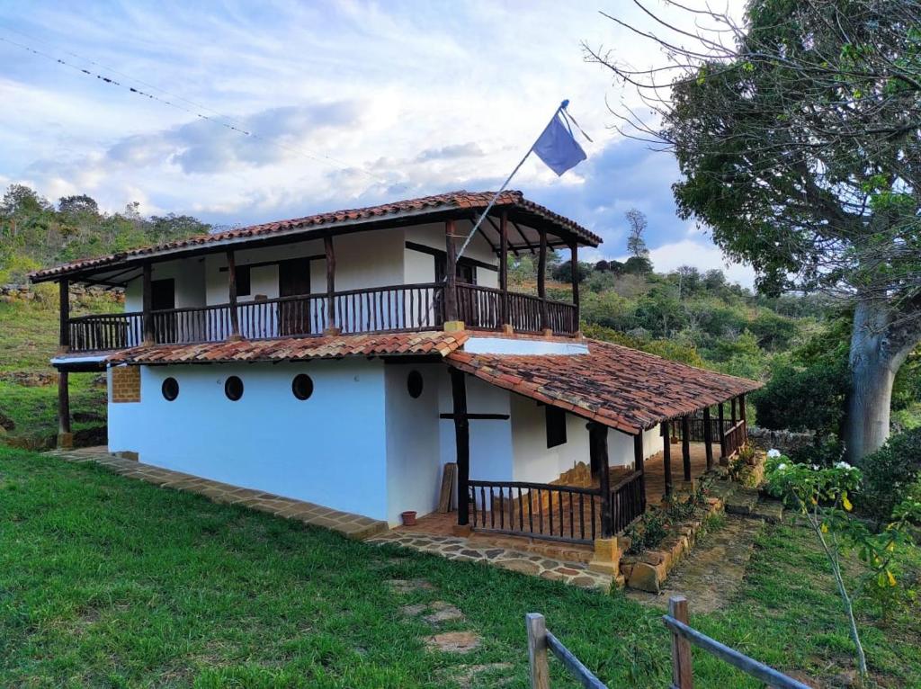 a house with a balcony and a flag on it at Casa Ceiba de Mirabel-Barichara in Barichara