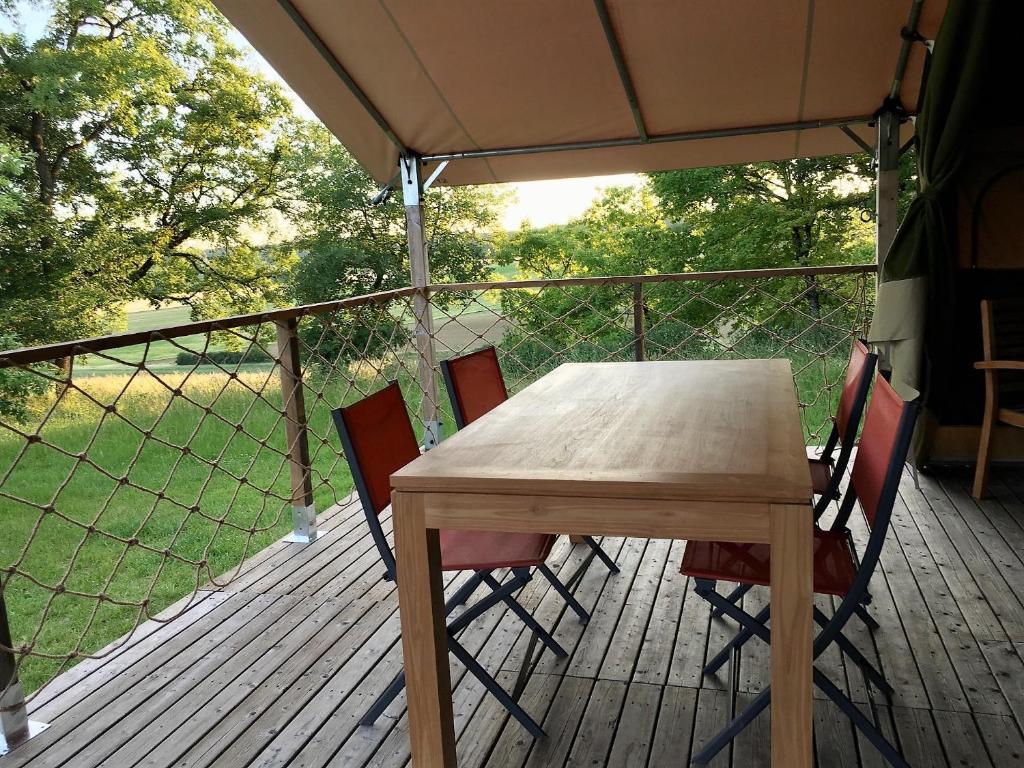 a wooden table and chairs on a deck at Maison d hôtes Casa Sana in Pillac