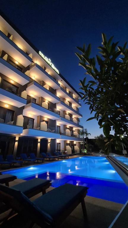 a large building with a swimming pool at night at Delight Hotel in Ksamil