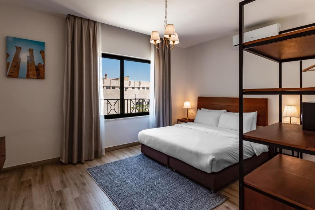 a bedroom with a bed and a large window at Canary Boutique Hotel in Amman