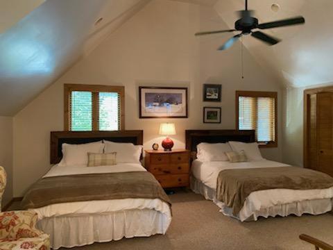 1 dormitorio con 2 camas y ventilador de techo en Lolly's Treehouse, en Highlands
