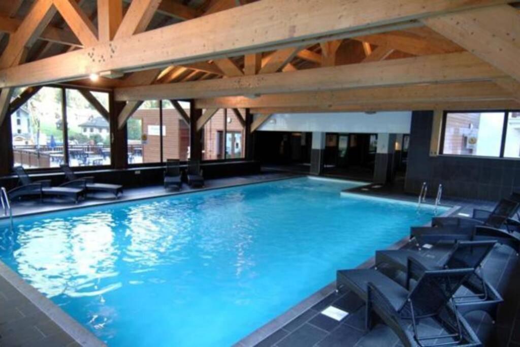 una gran piscina con sillas en un edificio en Large premium alpine apartment for 4 to 8 people, en Vallorcine