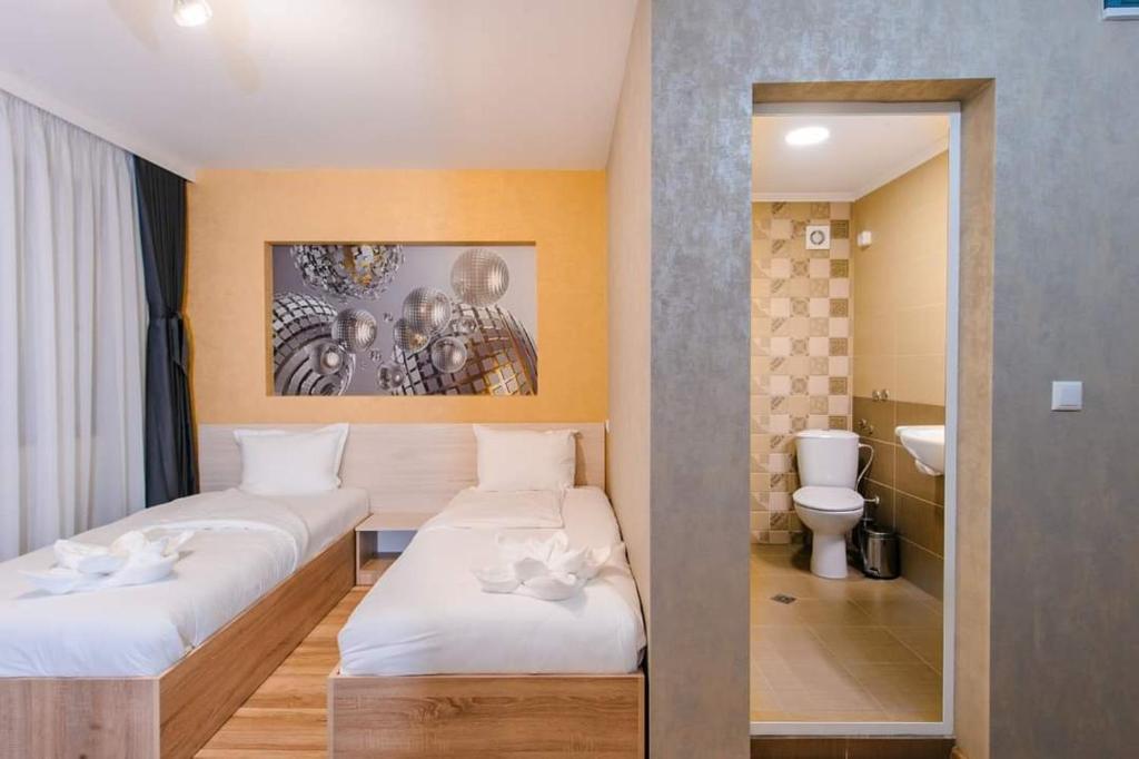 een hotelkamer met 2 bedden en een badkamer bij Пиргуля in Miladinowzi