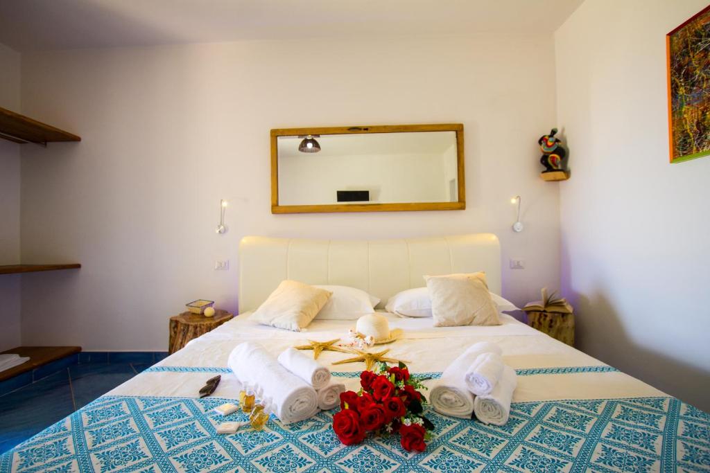 sypialnia z łóżkiem z ręcznikami i lustrem w obiekcie Suites Voce del Mare w mieście Tertenìa