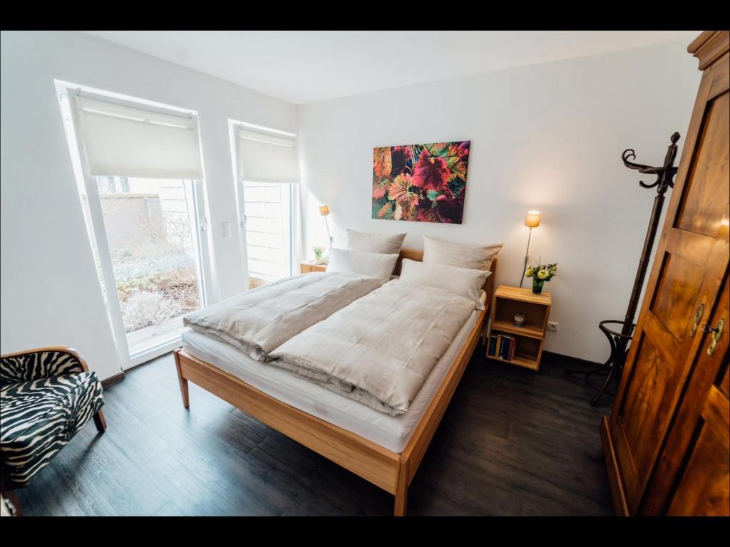 a bedroom with a bed and a large window at Weinreisedomizil mit eigenem Garten und Parkplatz in Deidesheim