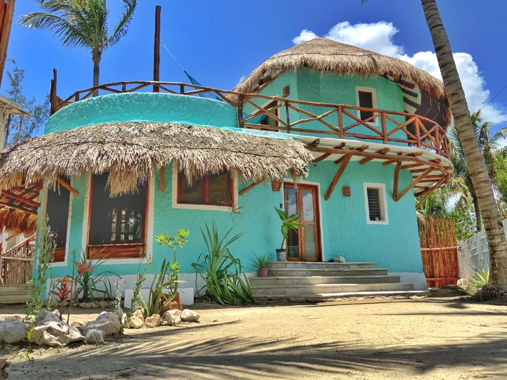 a blue house with a straw roof at Private house & garden - Casa privada con jardín - Casa Cacahuate Holbox in Holbox Island
