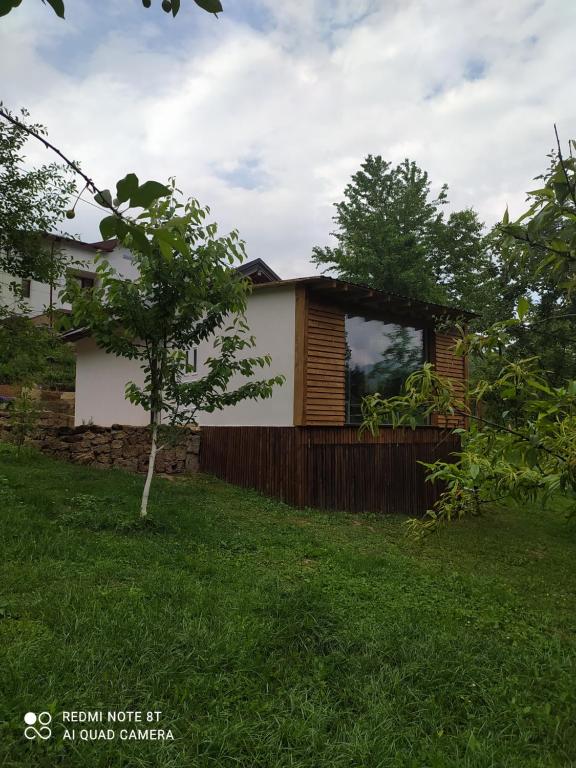 a house in a yard with a tree at Lenilenii Bungalows in Jajce