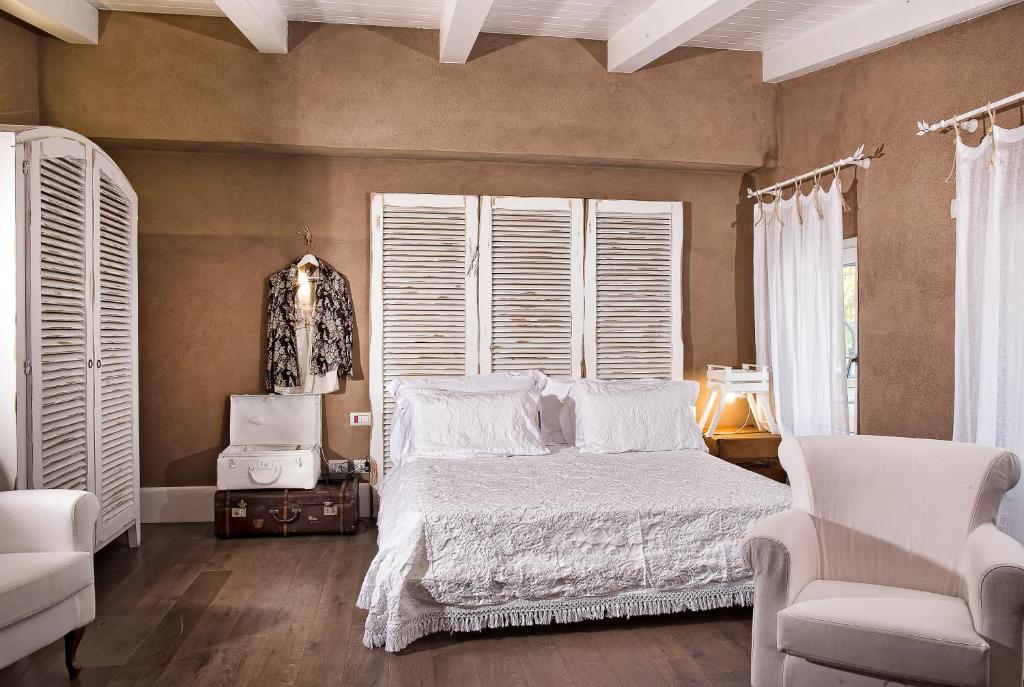 um quarto com uma cama, uma cadeira e janelas em La Pampa Relais & Spa em Melizzano
