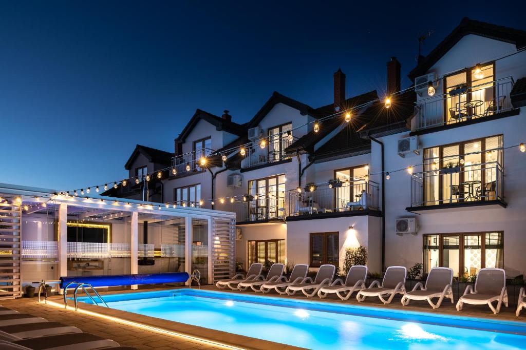 a villa with a swimming pool at night at Orbisa Bis in Łeba