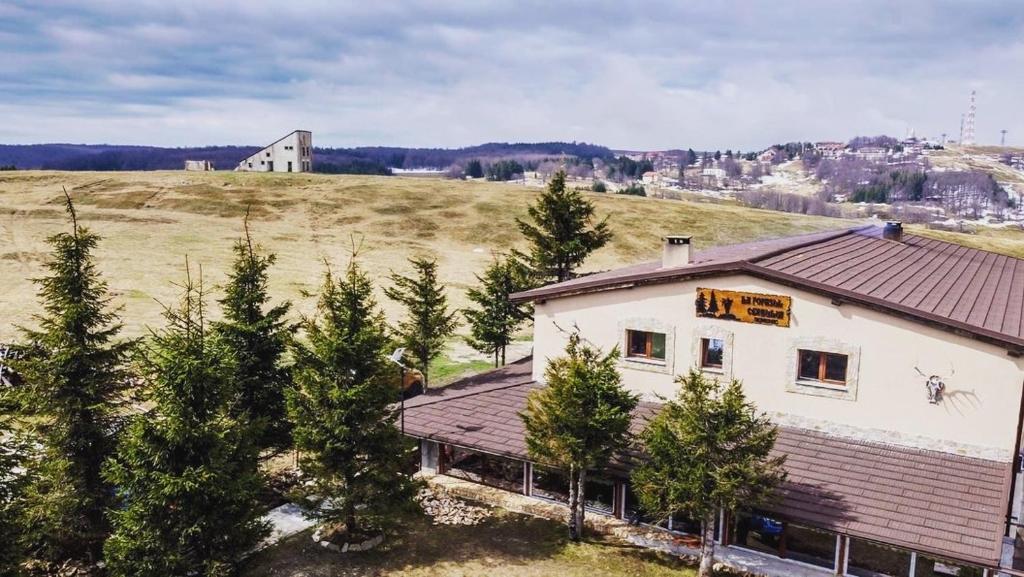 una vista aérea de una casa con árboles en un campo en La Popasul Cerbului en Semenic